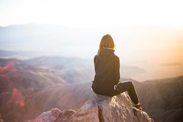Frau vor sonniger Aussicht auf hohem Berg